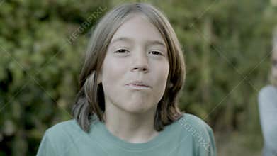 Slow motion of boy putting berry in mouth and chewing it