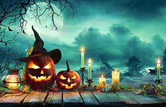 Halloween At Night - Pumpkins With Witch Hat And Candles On Table