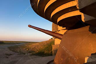 Gun emplacement at Omaha Beach. Bomb shelter with german long-range artillery gun from world war 2 in Longues-sur-Mer in Normandy.