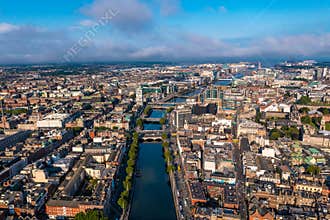 Establisher shot of Dublin skyline with river flowing with bridge connecting two sides of street surrounded by buildings
