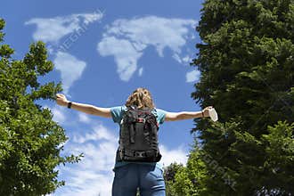 Woman dreams of returning to travel at the end of the coronavirus pandemic. Clouds with the shape of the world. Concept of freedom