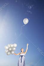 Woman Holding Balloons With One Flying Away