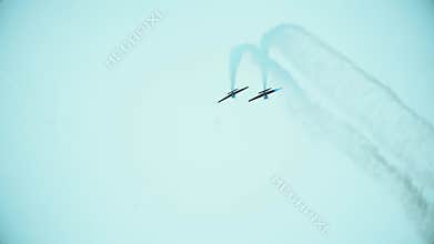 Telephoto lens shot of two propeller planes performing aerobatics maneuvers during the airshow. Teamwork or double