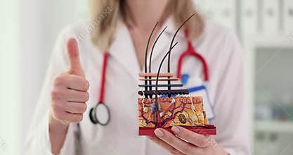 Doctor explains complex details of human skin model and gives thumbs up