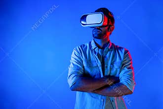Smart caucasian man using virtual reality glass while crossing arm. Deviation.