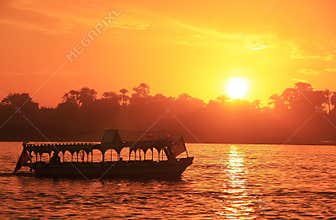 Boat cruising the Nile river at sunset, Luxor