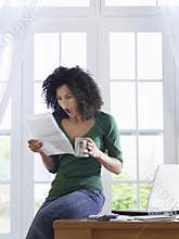 Shocked Woman reading document at home