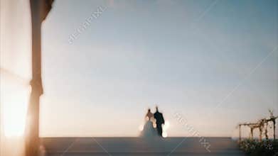 Bride and Groom Walking Toward Sunset