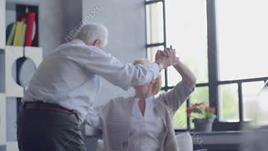 An Elderly Couple Joyfully Dancing Together in a Bright and Cheerful Room Full of Light