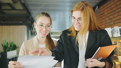 In a modern corporate office, successful businesswomen are actively engaged in professional discussions, collaboration