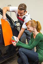 Car branding specialist consults a client about adhesive foils or films for auto wrapping