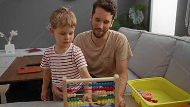 Man and son playing with an abacus in a living room at home creating loving family moments