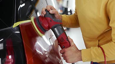 Male auto master providing professional detailing service in car studio