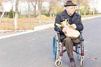 Elderly man in a wheelchair doing grocery shopping