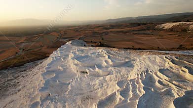 Aerial view of the travertines in Pamukkale in a beautiful sunset, Turkey. White limestone mineral formations. Turkish