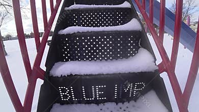 Diminishing perspective view of the steps of slide. Slide - Kids play area equipment covered with snow