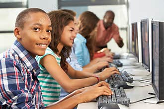 Group Of Students Working At Computers In Classroom