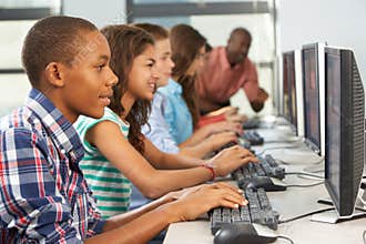 Group Of Students Working At Computers In Classroom