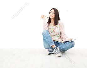 Beautiful girl teenager thinking sitting on floor.