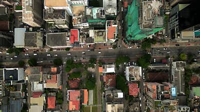 Aerial top view of vibrant Asian cityscape with dynamic traffic, busy streets with moving cars, scooters. Urban layout