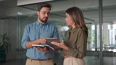 Happy busy latin partners working with digital tablet talking in office.