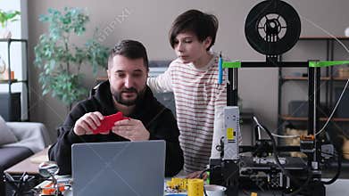 Son And Father Engaged In Constructing Project Researching