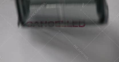 Person poses canceled stamp in closeup. Cancel message denied and blocked