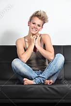 Portrait of a candid fashion woman sitting on a couch