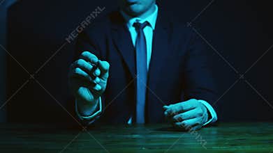 A male consultant in a suit explains the operation of the assets to the client. Gestures with his hands. Dark blue