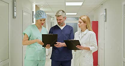 Medical Team Discussing Reports In Hospital Corridor
