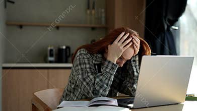 Exhausted female student or worker sit at home office desk looking away having sleep deprivation. Lazy millennial woman