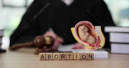 Word Abortion with wooden cubes on judge counter in office