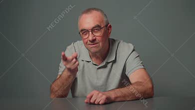 Aged dissatisfied man in gray t-shirt making admonishing gesture, disapproval sign, saying no and warning about threaten