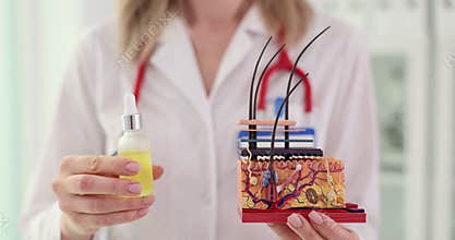 Doctor explains structure of skin and holds bottle of oil