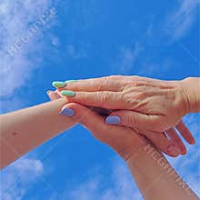 hands on the background of a summer blue sky with clouds