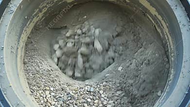Small pebbles and gravel are added to the cement mixer creating a textured and durable concrete..