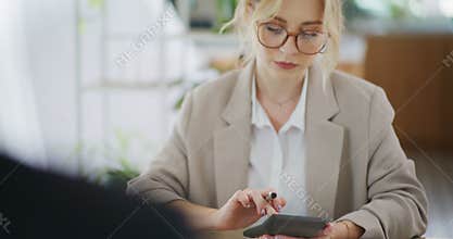 Woman Using Calculator While Working in Office