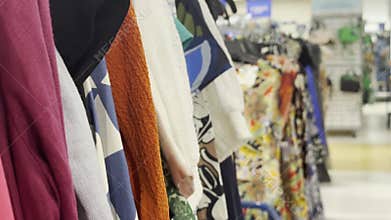 rack of colorful clothing items hanging in a retail store, with various fabrics and patterns on display