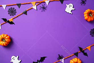 Halloween frame of bunting, ghosts, pumpkins, bats, spiders on purple background. Flat lay, top view, copy space