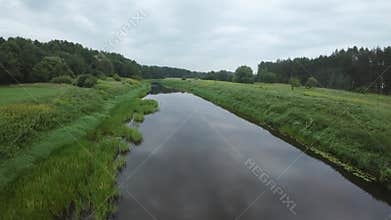 Tranquil river reflecting sky through lush green landscape