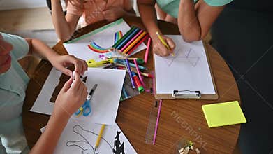 Children engaged in creative back to school art activities with colorful stationery on a wooden table, highlighting