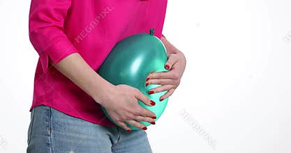 Lady compresses green balloon into body by pressing in middle