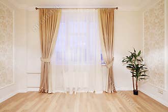 Window with beige curtains in simple room
