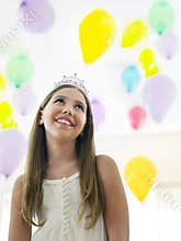 Girl In Tiara Looking Up Against Balloons