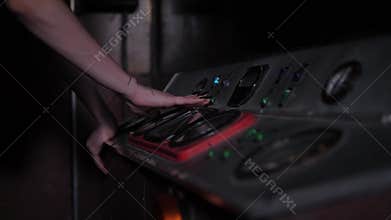 A woman presses buttons and levers on an old control panel in a subway car.Quest