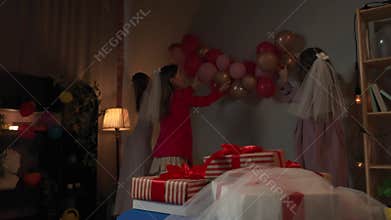 Group of young women friends and bride celebrating bachelorette party at home, bridesmaids decorating party room with