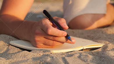 Man writing in his diary at the beach