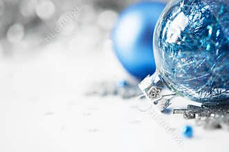 Blue and silver xmas ornaments on bright holiday b