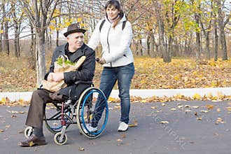 Woman helping a disabled pensioner in a wheelchair