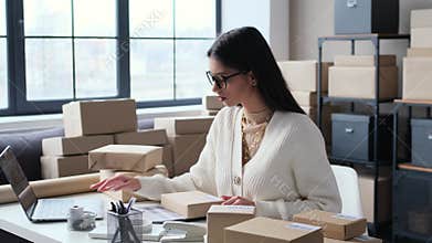 Woman Review Package And Adding Tags While Working In The Office